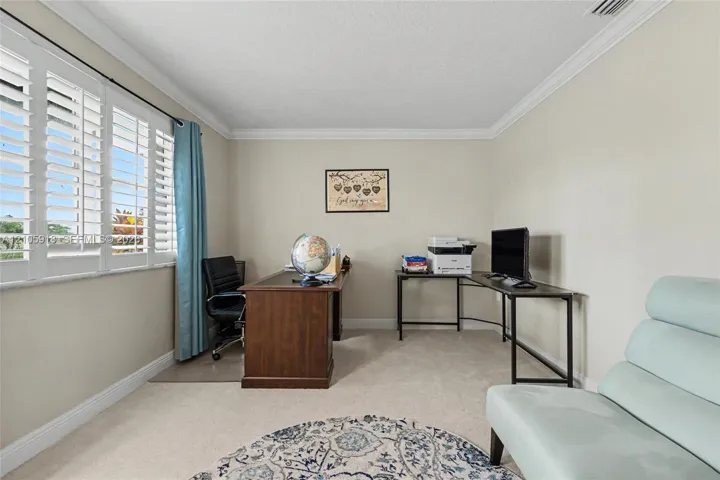 Neutral interior space featuring crisp crown molding, wall-to-wall carpeting, and plantation shutters