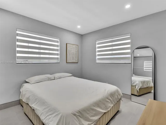 Neutral wall tones featuring dual-tone striped window shades and recessed ceiling lighting throughout