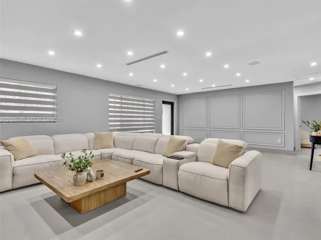 Interior space featuring recessed lighting, large-format tile flooring, wall molding detail, and dual-layered window shades