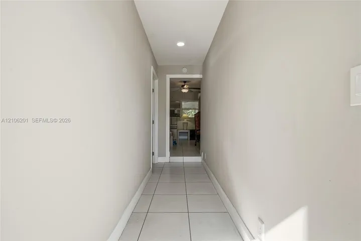 Hallway featuring ceramic tile flooring, recessed ceiling lighting, and neutral wall paint