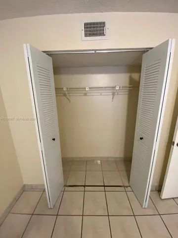 Reach-in closet featuring white louvered bifold doors and wire shelving