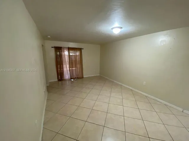 Interior space featuring diagonal ceramic tile flooring, neutral wall tones, and glass sliding doors