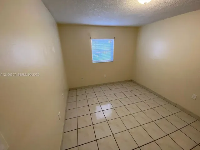 Interior room featuring neutral-toned wall paint and ceramic tile flooring
