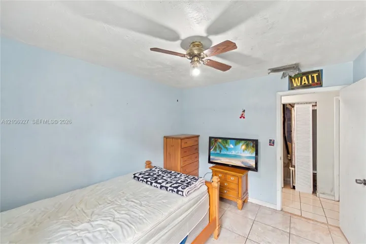 Room featuring tile flooring and a ceiling-mounted fan with light fixture