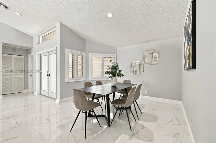 High-gloss tile flooring, vaulted ceilings, double entry doors with glass inserts, transom windows, and window shutters