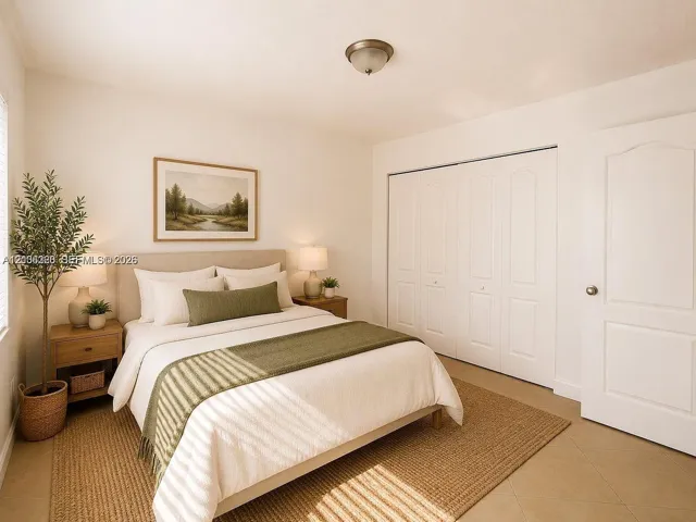 Neutral interior featuring tile flooring, a multi-panel door, and a spacious floor-to-ceiling closet with bi-fold doors