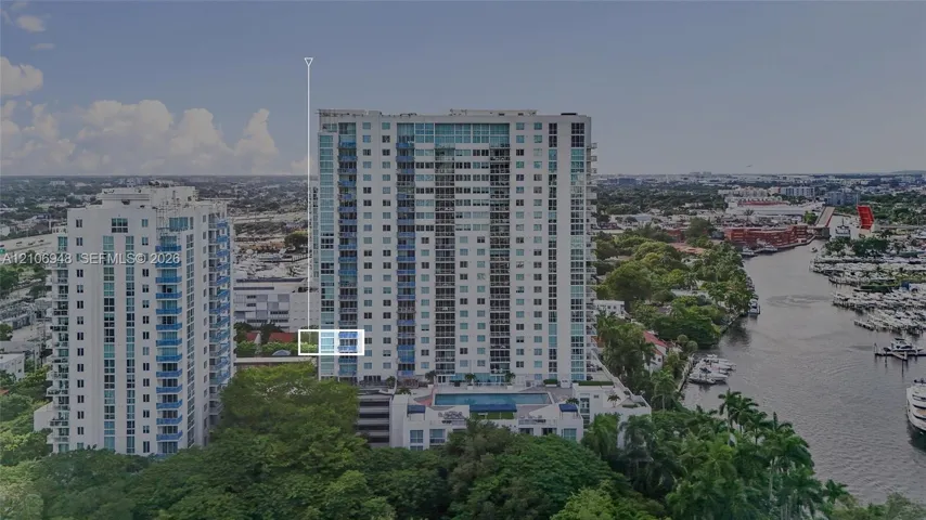 High-rise residential building featuring floor-to-ceiling glass windows, exterior balconies, and an elevated outdoor swimming pool