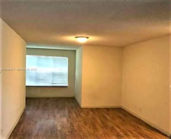 Wood-finish flooring, neutral wall tones, and recessed ceiling lighting