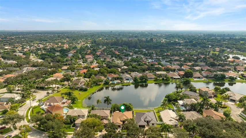 Aerial perspective featuring a waterfront property with a concrete tile roof and a screened-in lanai