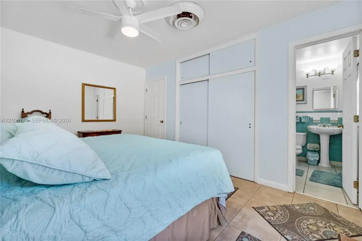 Interior space featuring tile flooring, ceiling fan with integrated lighting, and floor-to-ceiling sliding closet doors