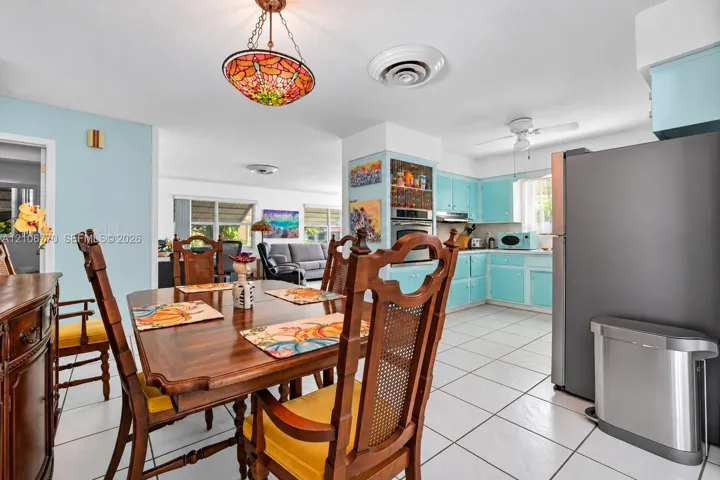 Kitchen featuring light blue cabinetry, tile flooring, built-in wall oven, and a decorative stained-glass pendant light fixture