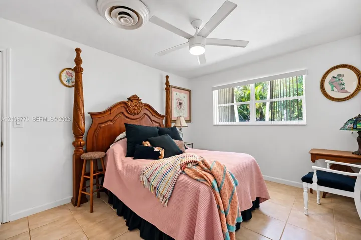 Neutral-toned tile flooring, ceiling fan with integrated lighting, and horizontal window blinds
