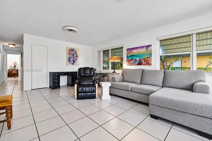 Neutral ceramic tile flooring, clean white wall finishes, and large windows providing natural light