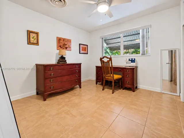 Room featuring neutral walls, large-format tile flooring, a ceiling fan with integrated lighting, and a horizontal window with adjustable blinds
