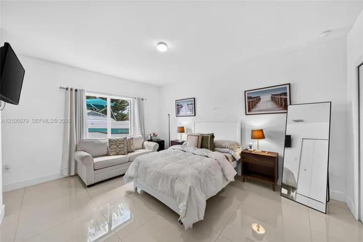 Neutral-toned interior space with polished large-format tile flooring and a double-hung window