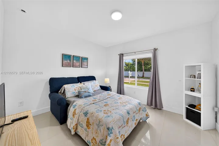 Neutral-toned tile flooring, single-pane window with natural light, and ceiling-mounted lighting
