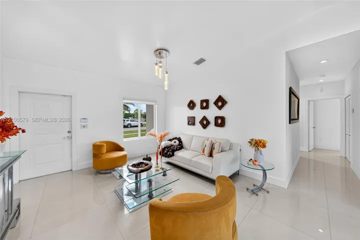 Neutral-toned tile flooring, recessed lighting, and a modern tiered glass pendant fixture