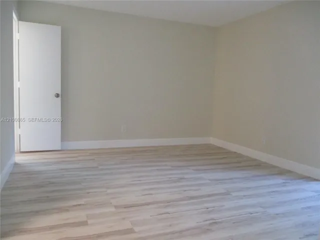 Master bedroom Interior room featuring neutral-toned walls and wood-finish flooring