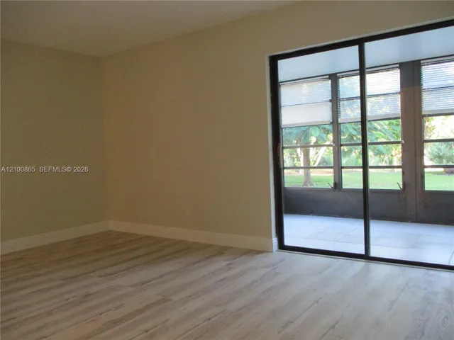 Entrance from sliding door into the master bedroom. Interior space featuring wood-finish flooring, neutral wall paint