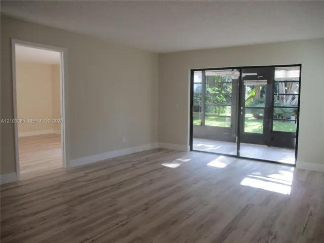 sliding glass doors to outdoor area, neutral wall tones, and white trim