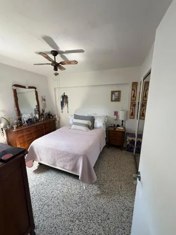 Room featuring speckled terrazzo flooring, a ceiling fan with integrated lighting, and a closet with mirrored sliding doors