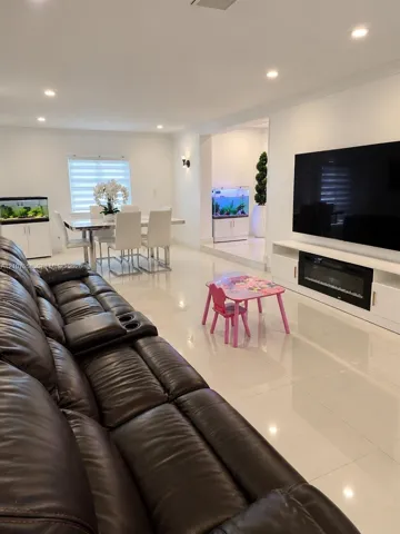 Polished tile flooring, recessed lighting, wall-mounted electric fireplace with integrated cabinetry, and horizontal blind window treatments