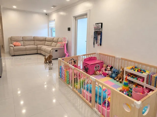 Spacious interior featuring large-format polished tile flooring, recessed ceiling lighting, and a glass-paneled entry door