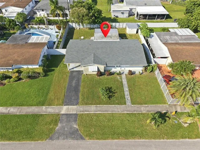 Single-story residence featuring a shingled roof, stone-veneer exterior facade, concrete driveway, and a fenced perimeter