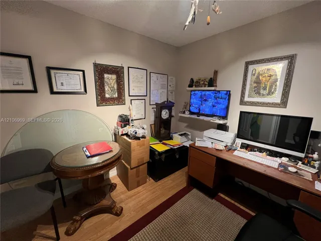Room featuring wood-finish flooring and wall-mounted shelving