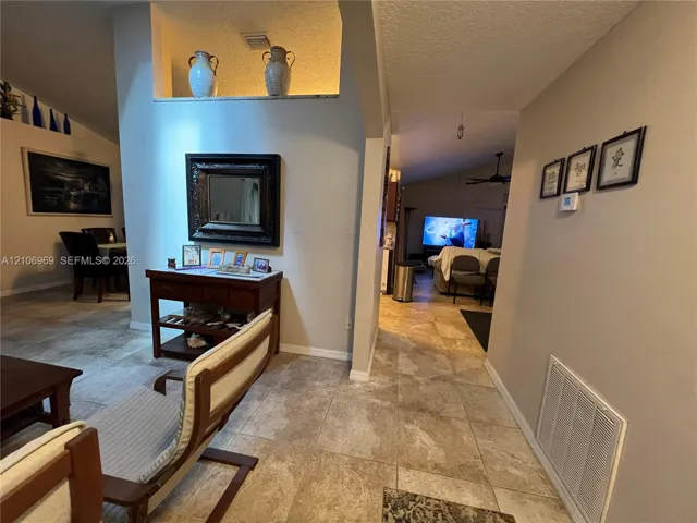 Vaulted ceilings, large-format tile flooring, and a decorative recessed architectural niche