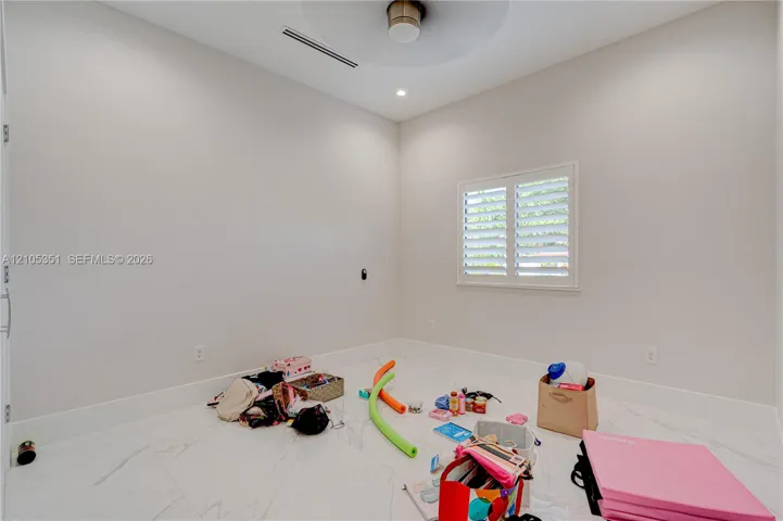 Neutral interior featuring white stone-finish flooring, high ceilings with recessed lighting, and a dual-tone circular light​​‌​​​​‌​​‌‌​‌‌​​​‌‌​‌​‌​‌​​​‌​​ fixture