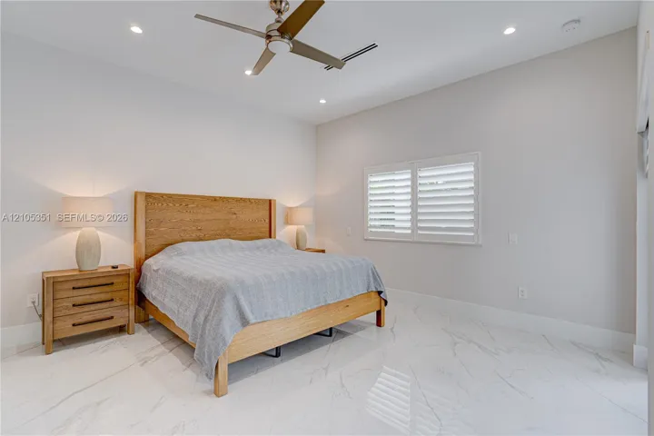 High ceilings, polished stone-finish flooring, recessed lighting, ceiling fan, and plantation shutters
