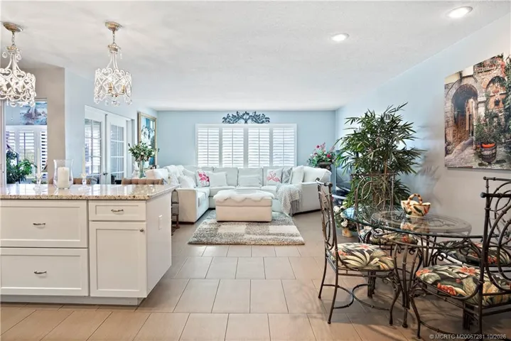 Living Room with Plantation Shutters, French Doors lead to the Enclosed Sunroom - Very Tasteful Furniture and Decorative Items are included in this Offering.