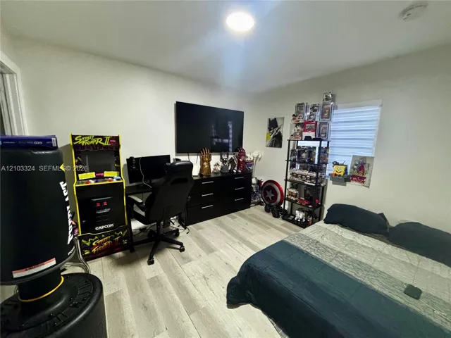 Room featuring neutral-toned walls, wood-finish flooring, and horizontal window blinds
