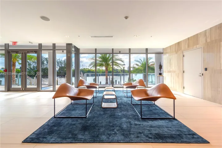 Waterfront Lobby. Floor-to-ceiling glass paneling, tile flooring, natural stone wall finish, and exterior water access