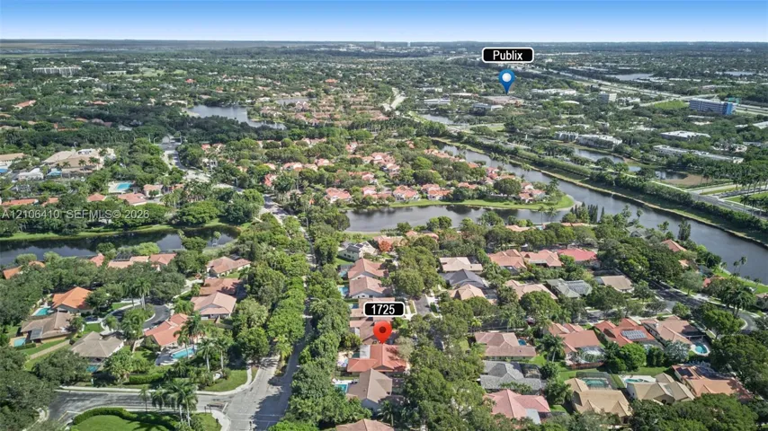 Aerial perspective highlighting mature tree canopy, neighborhood lakes, and established residential landscaping