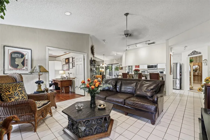 Open-concept living space featuring vaulted ceilings, ceramic tile flooring, a ceiling fan, and recessed lighting