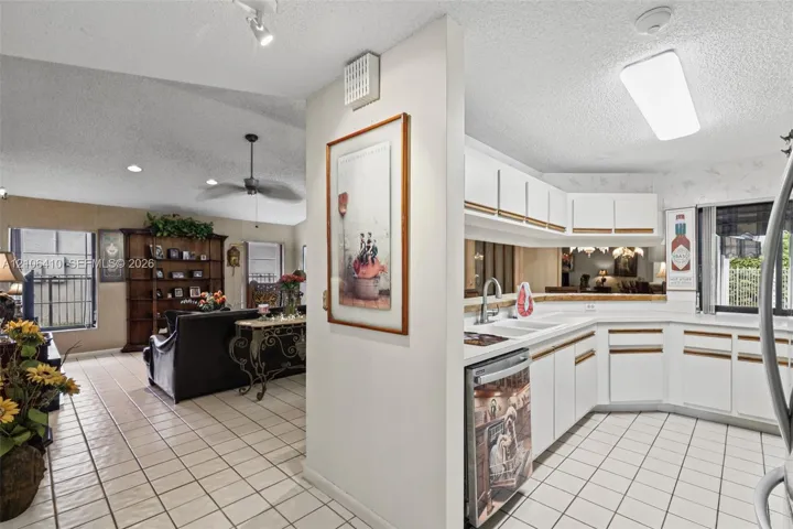 Kitchen featuring white cabinetry, ceramic tile flooring, and integrated lighting