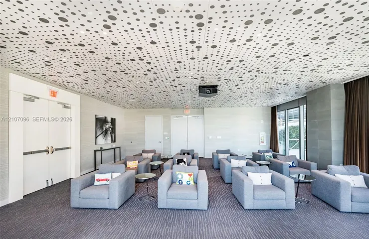 Custom patterned acoustic ceiling tiles, neutral wall textures, and double-door entry