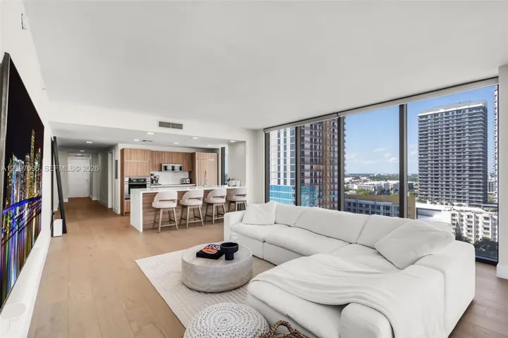 Open-concept living space featuring wood-finish flooring, floor-to-ceiling windows, and recessed lighting