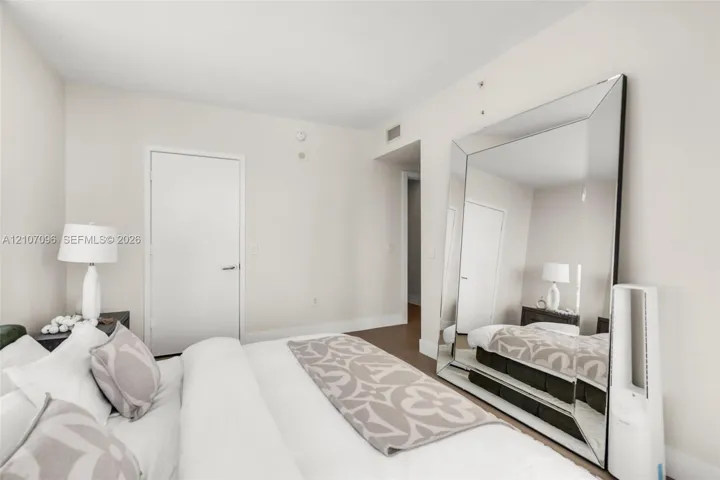 Neutral-toned interior space featuring wood-finish flooring and solid-core interior doors