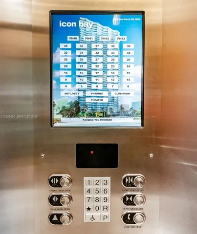 Brushed stainless steel elevator control panel featuring an integrated digital touchscreen interface, illuminated push-button keypad, and dedicated emergency communication controls