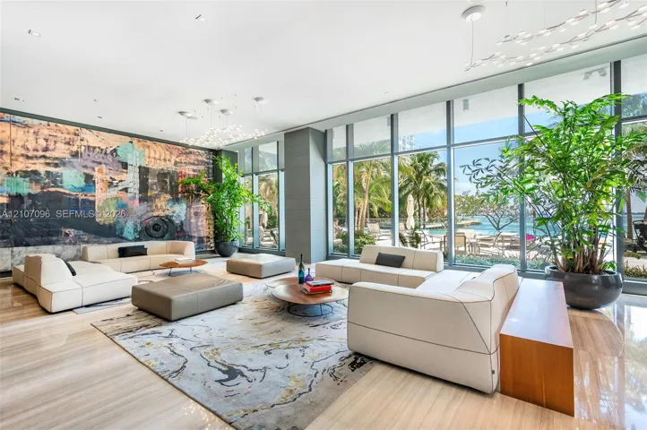 Floor-to-ceiling glass windows, polished stone flooring, recessed lighting, architectural wall-mounted lighting fixtures, and large-scale decorative wall installation