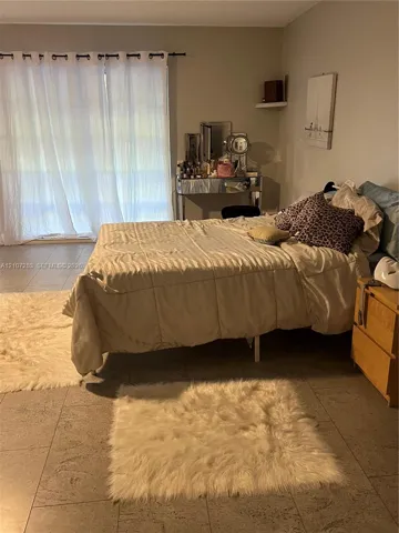 Large-format neutral tile flooring and sliding glass door with integrated drapery rod