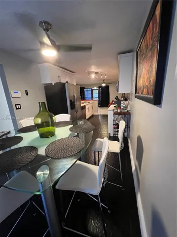 Kitchen featuring stainless steel appliances, white cabinetry, dark flooring, and recessed ceiling lighting
