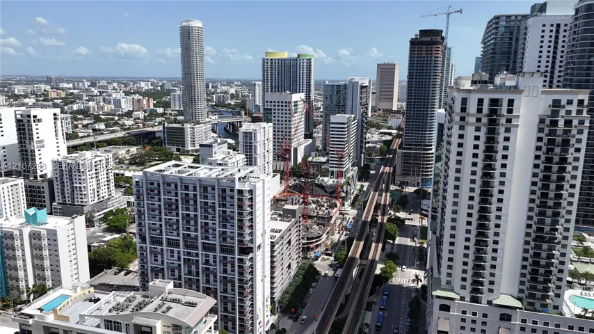 High-rise urban landscape featuring numerous multi-story residential towers, dense metropolitan architecture, and an elevated transit corridor
