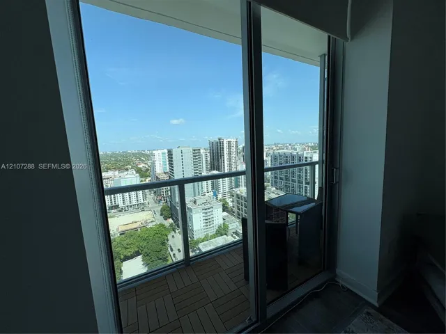 Balcony featuring interlocking composite wood-finish decking and floor-to-ceiling sliding glass doors with a metal frame