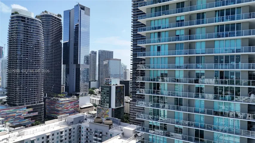High-rise residential exterior featuring expansive glass-paneled balconies and a contemporary facade