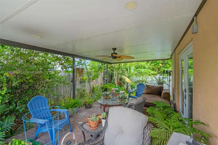 Covered outdoor patio featuring brick pavers, a ceiling-mounted fan, recessed lighting, and glass-paneled double doors