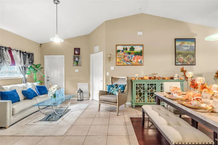 Vaulted ceilings, neutral wall tones, ceramic tile flooring, and a pendant light fixture